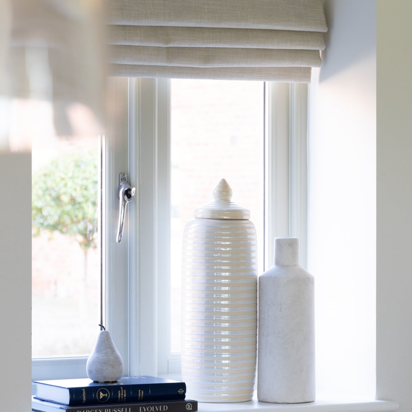 Ribbed Glass Jar with Lid used as a decorative centerpiece on a modern window sill.