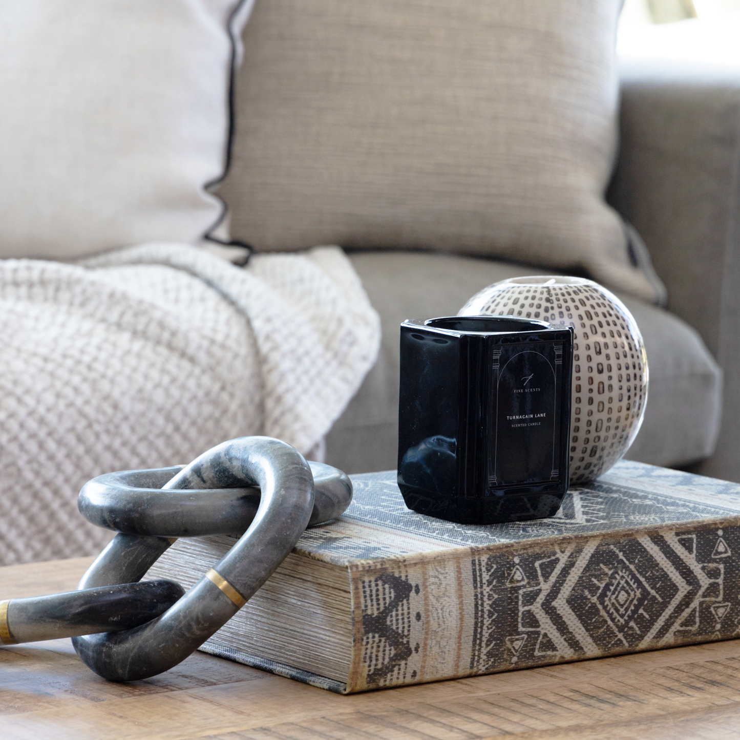 Linen Book Box used to discreetly store remote controls on a coffee table.