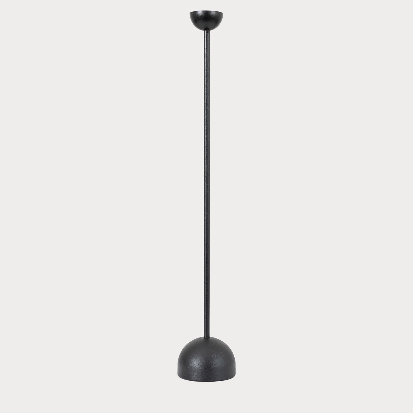 Black iron candlestick with a lit candle, creating a warm ambiance in the living room.