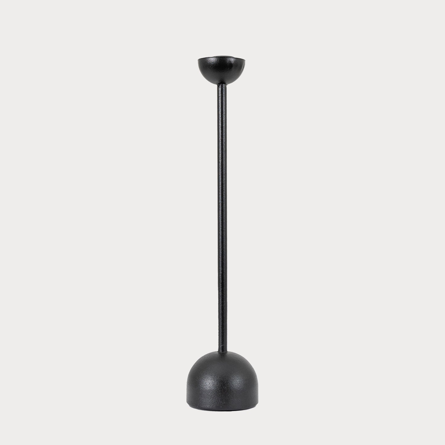 Large black iron candlestick displayed on a modern dining table.