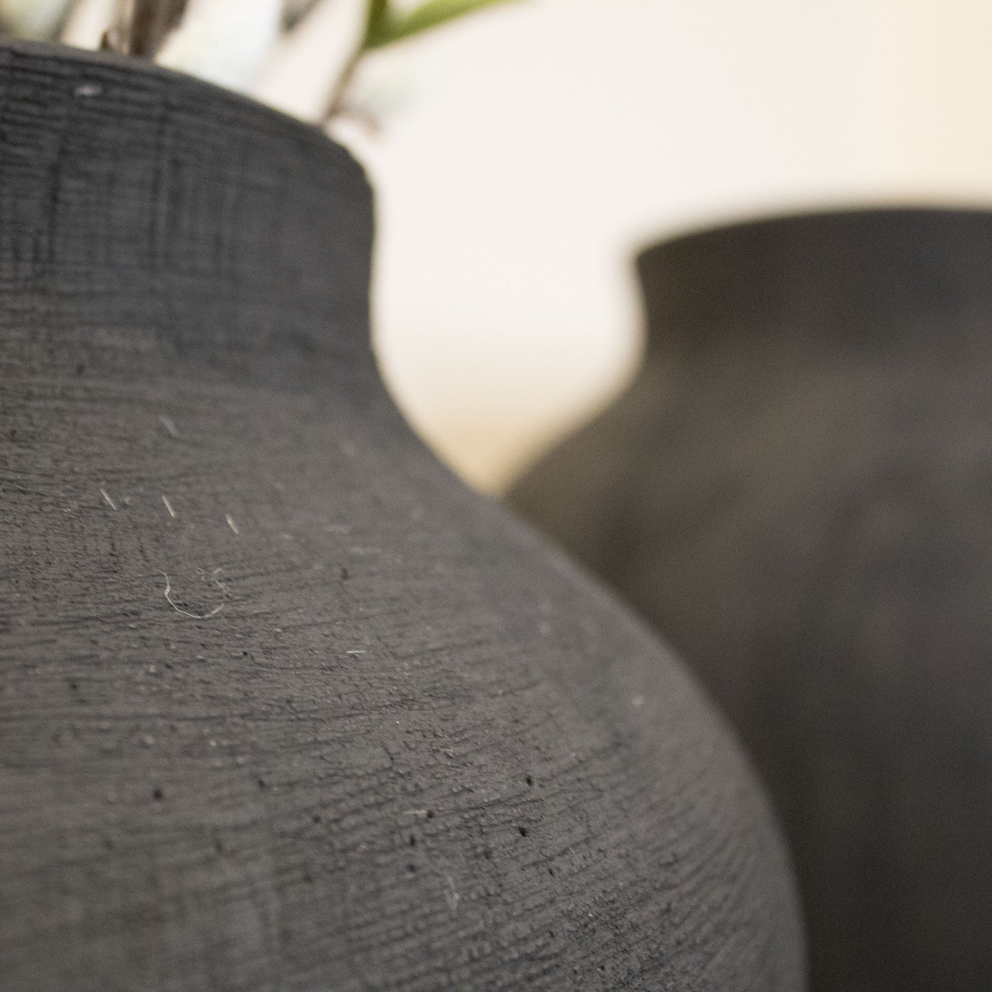Side view of the Black Textured Vase highlighting its sleek design and durable stoneware material.