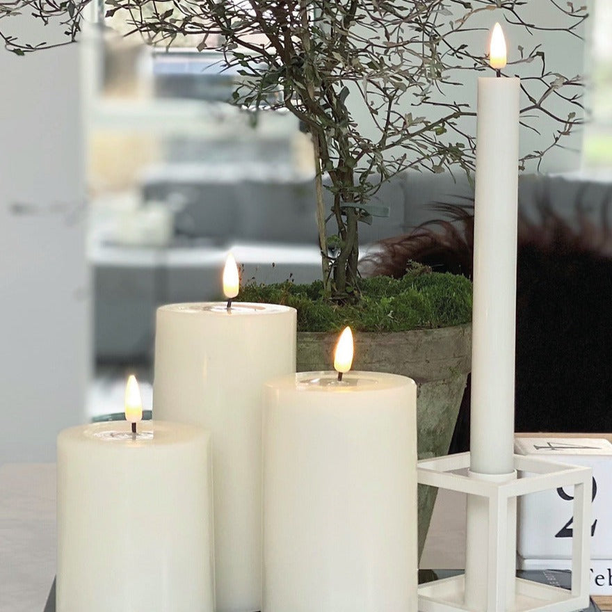 Set of multiple Wide White Indoor LED Candles creating ambient lighting in a dining area.