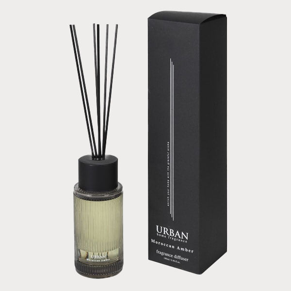 Close-up of Moroccan Amber Reed Diffuser's glass bottle with amber-colored fragrance.