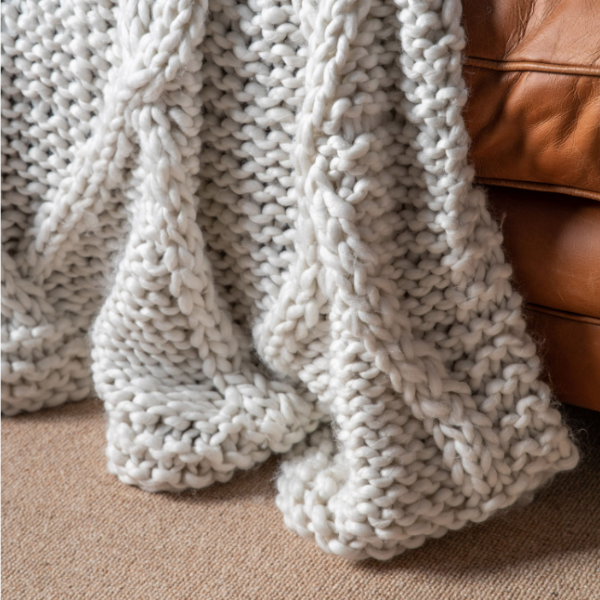 Knitted Diamond Throw styled in a bedroom setting, enhancing the cozy ambiance.