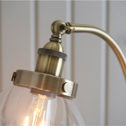 Side view of the Antique Brass Floor Lamp illuminating a modern living room setting.