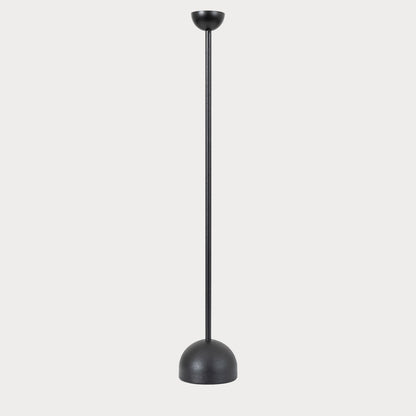 Black iron candlestick with a lit candle, creating a warm ambiance in the living room.
