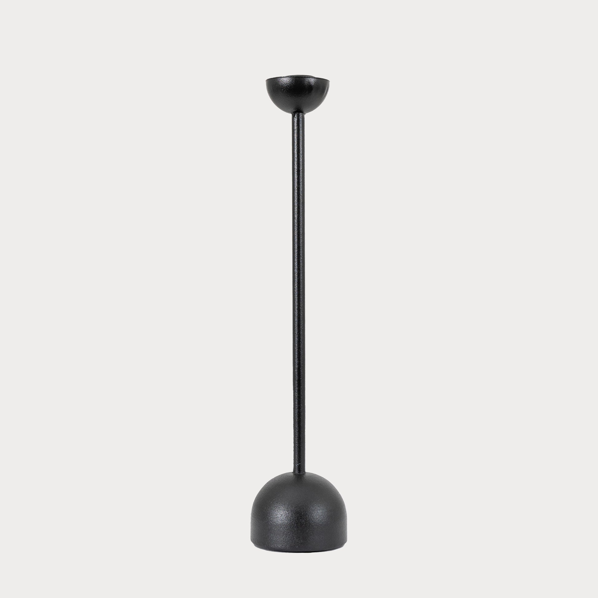 Large black iron candlestick displayed on a modern dining table.