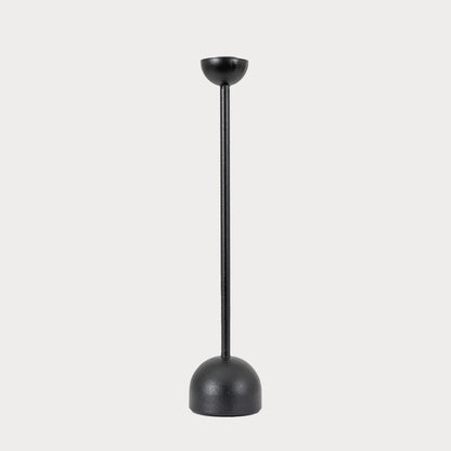 Large black iron candlestick displayed on a modern dining table.