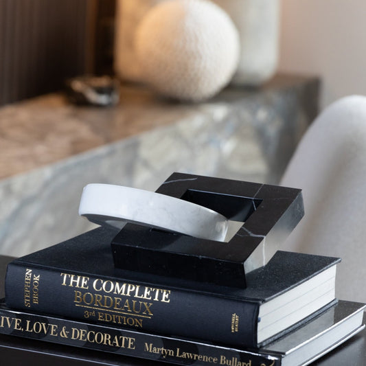 Interlocked Marble Sculpture featuring black and white marble intertwined in a modern abstract design, available at Clarkson Lee Lifestyle.
