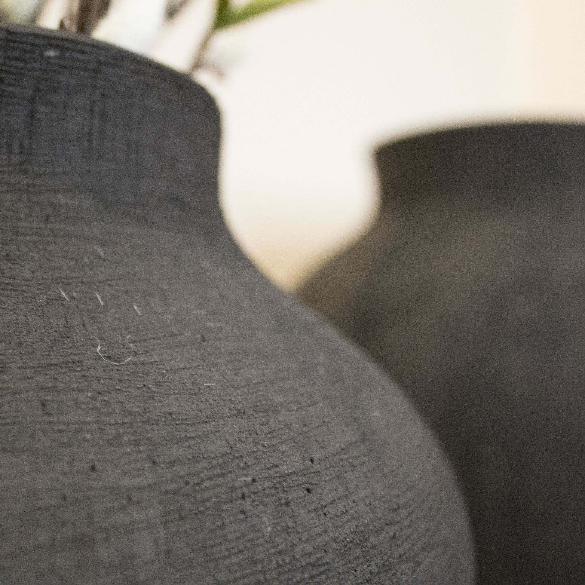 Side view of the Black Textured Vase highlighting its sleek design and durable stoneware material.