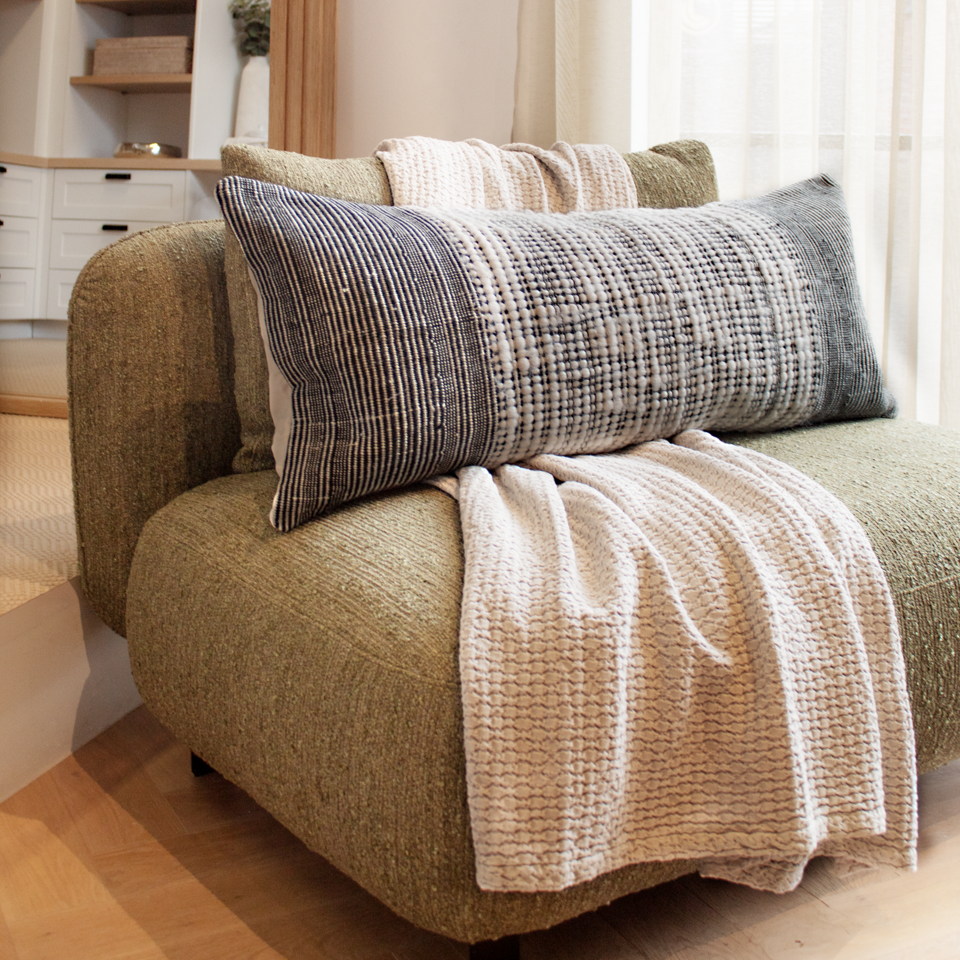 Both sizes of the Recycled Black & Neutral Cushion displayed together, illustrating versatility in home décor.