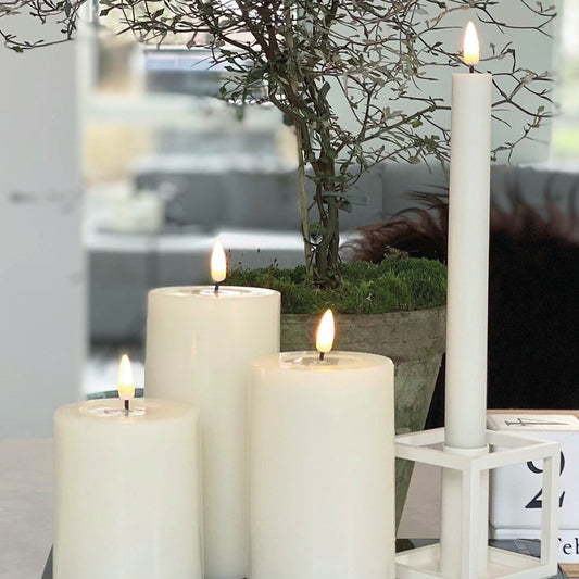 Set of multiple Wide White Indoor LED Candles creating ambient lighting in a dining area.
