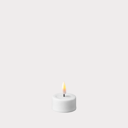 White LED Tealights placed in decorative holders on a dining table.