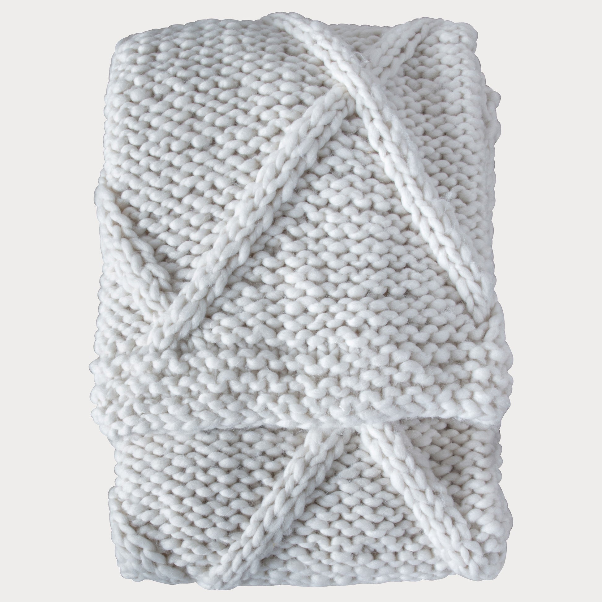 Knitted Diamond Throw in Cream folded neatly, highlighting its soft texture.