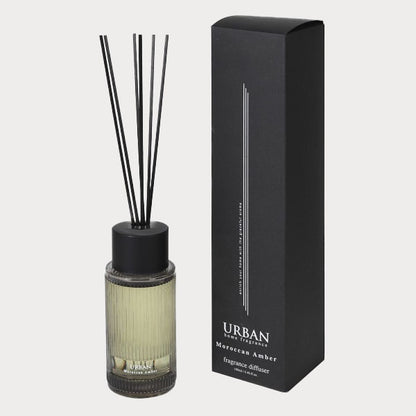 Close-up of Moroccan Amber Reed Diffuser's glass bottle with amber-colored fragrance.